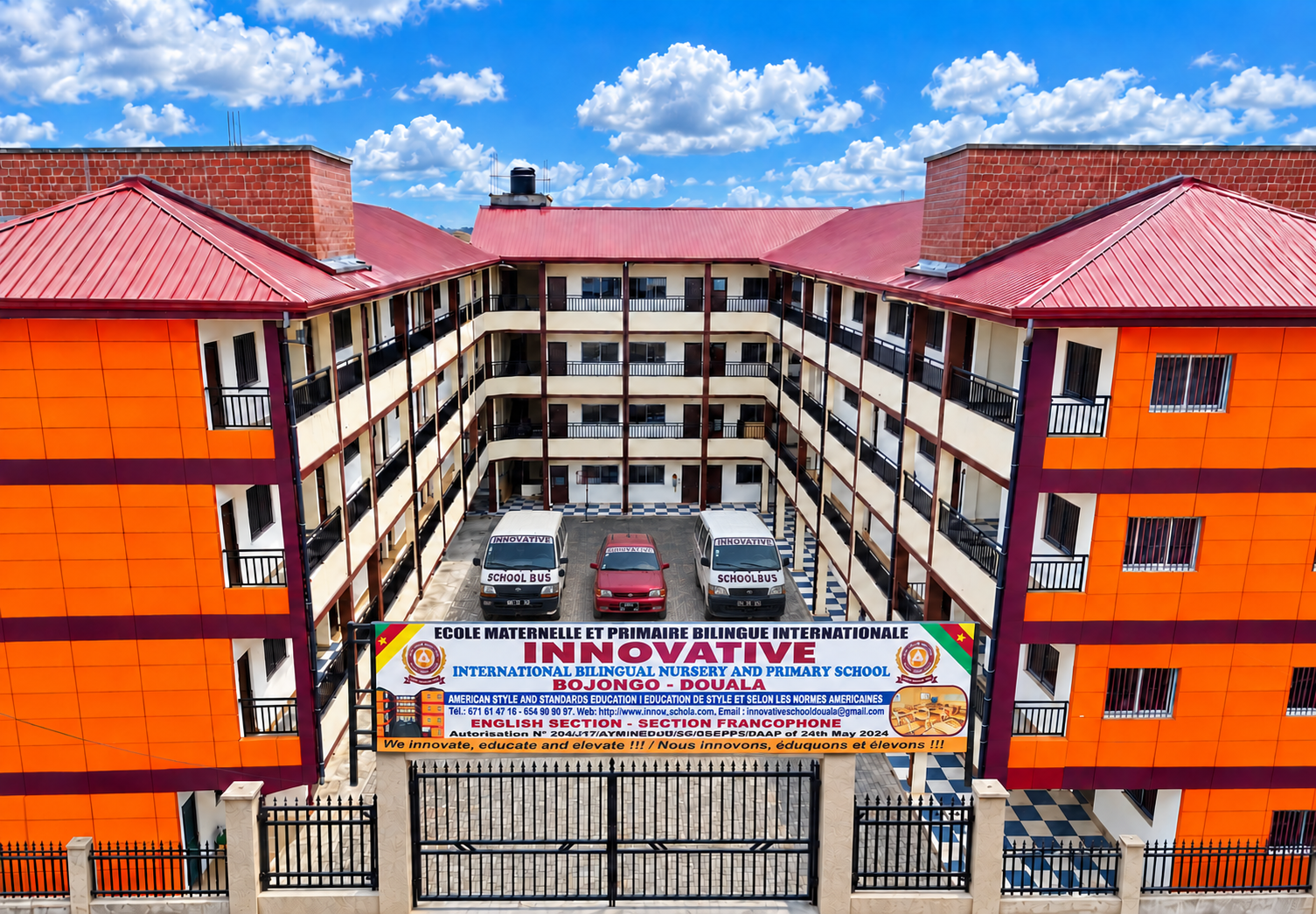 Our school building, entrance signboard and three school vehicles in the courtyard