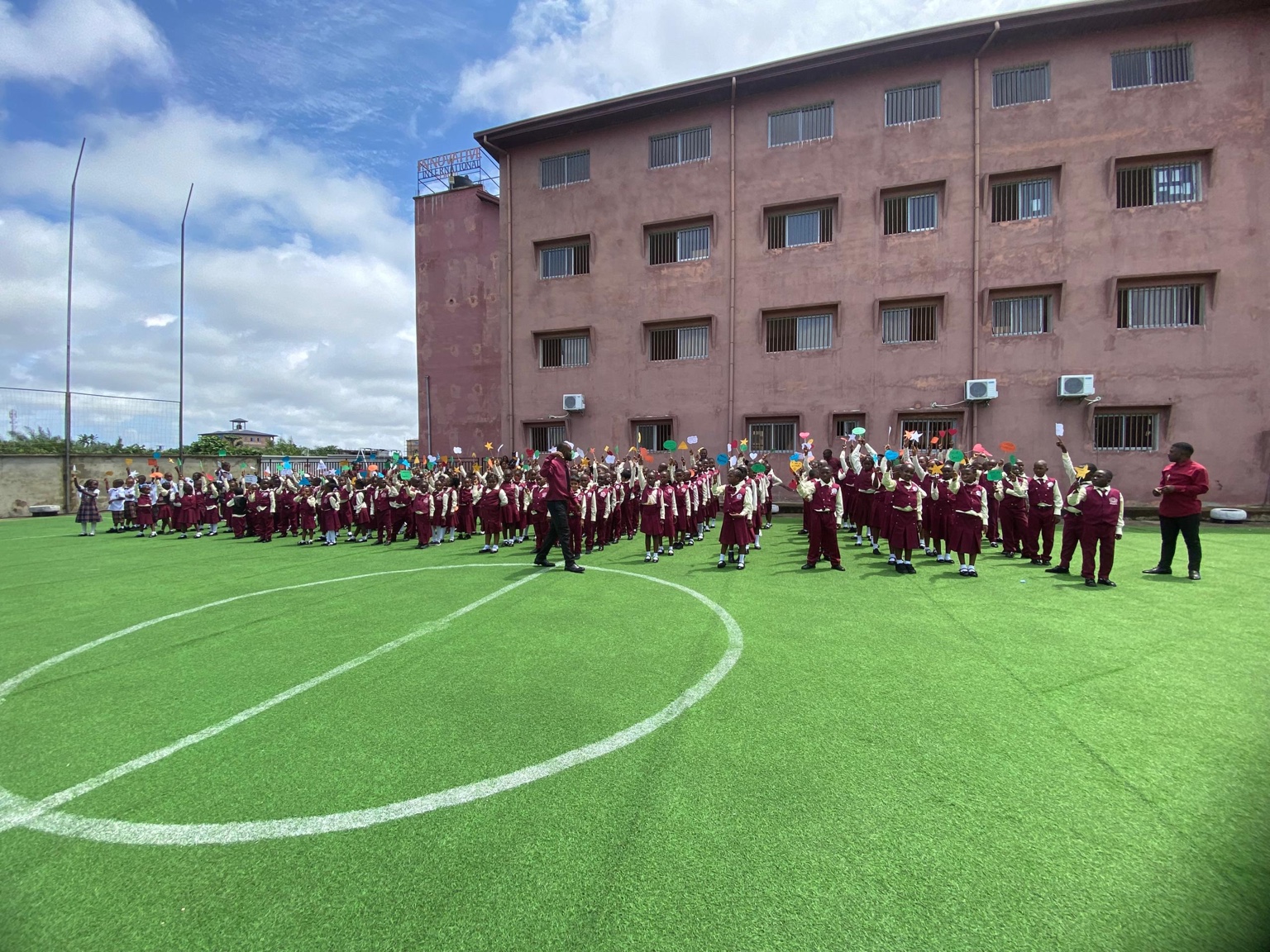 The school community gathered on the field in front of the building