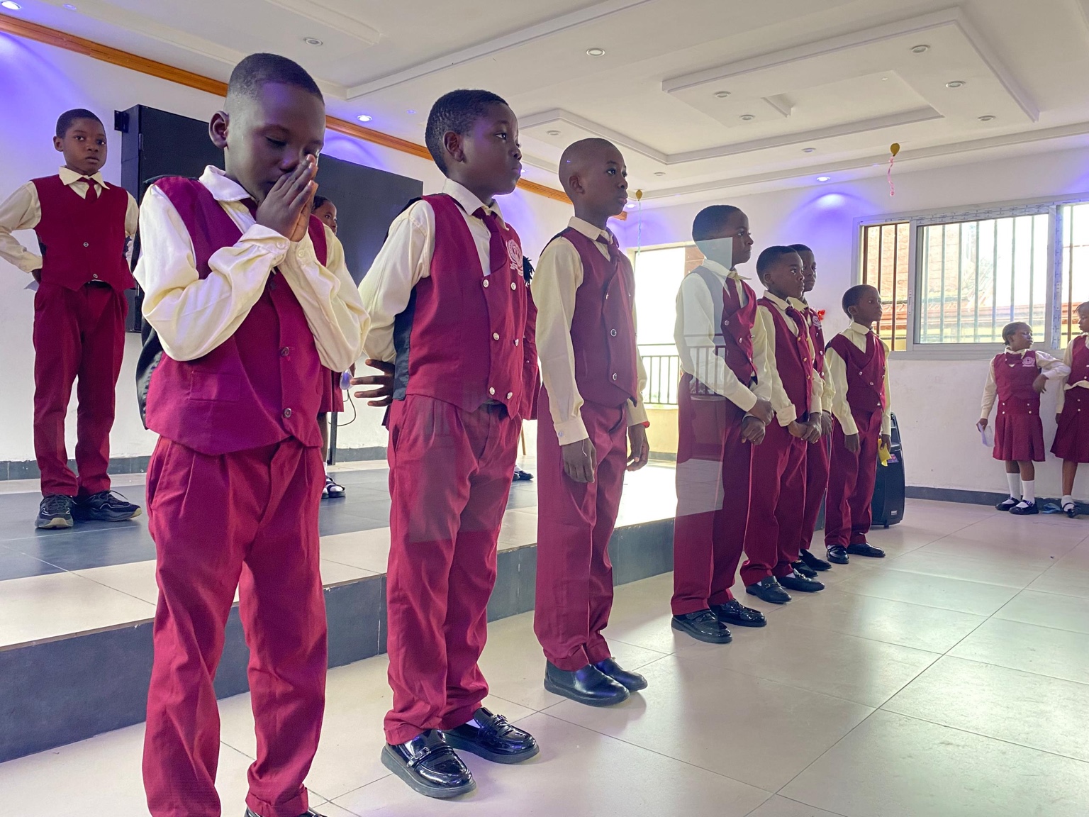 Innovative pupils in official uniform standing together on stage